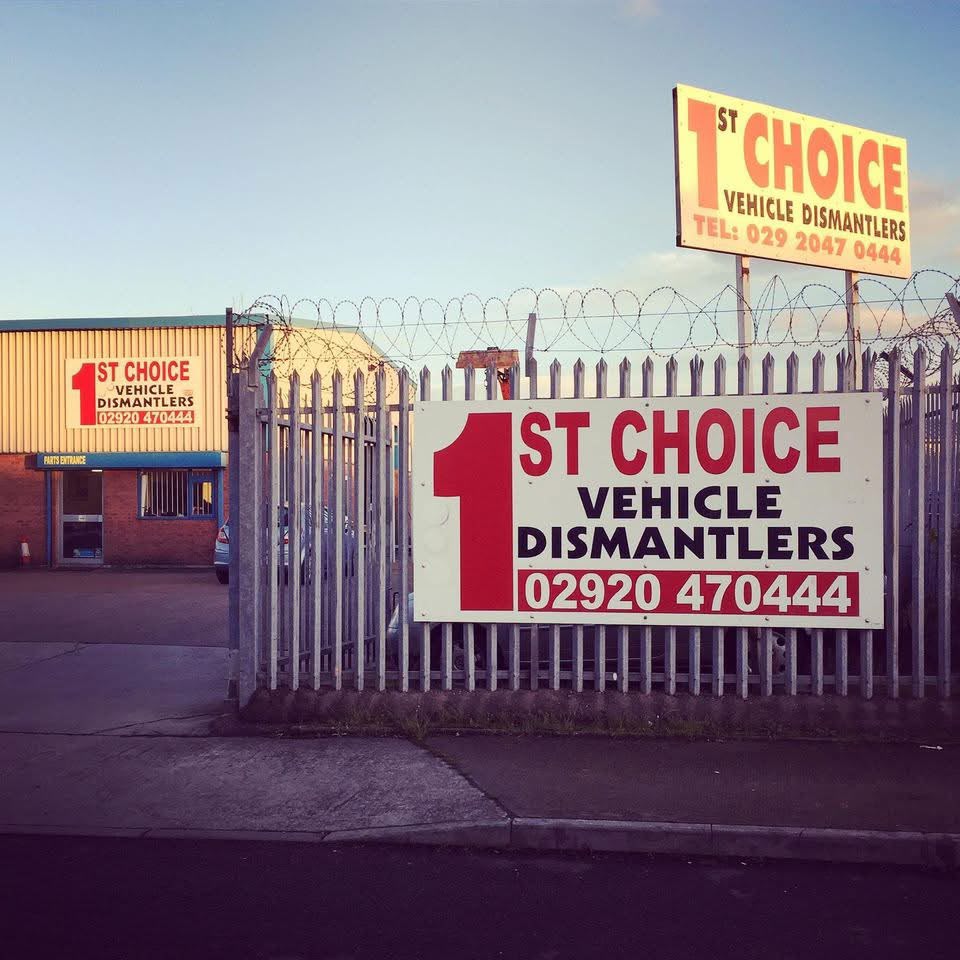 The front of 1st Choice Vehicle Dismantlers on Martin Road: the red 1st Choice sign on the fence, the tall sign above it and the parts entrance behind